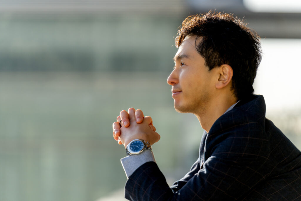 遠くを見つめて微笑む男性ビジネスマン