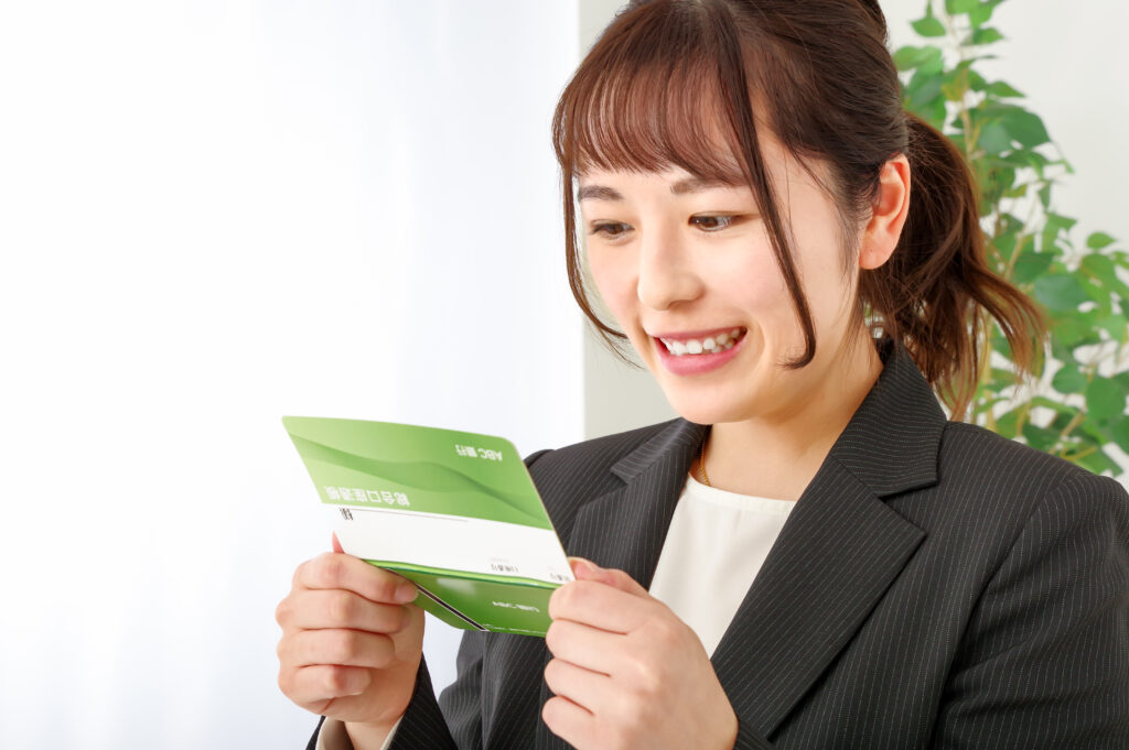 通帳をみて嬉しそうな表情をする女性