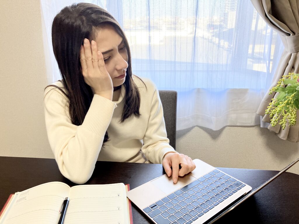 パソコンを見ながら考える女性 テレワーク