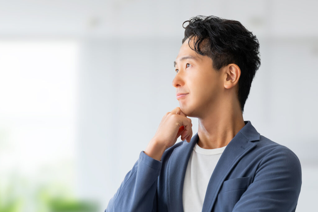 考えごとをする男性ビジネスマン