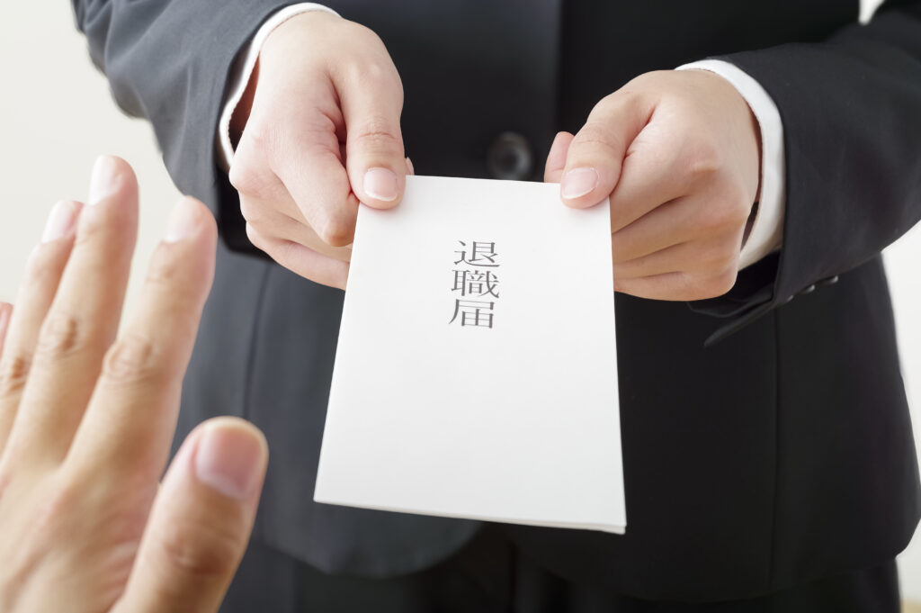 退職届を提出する女性と引き止める上司