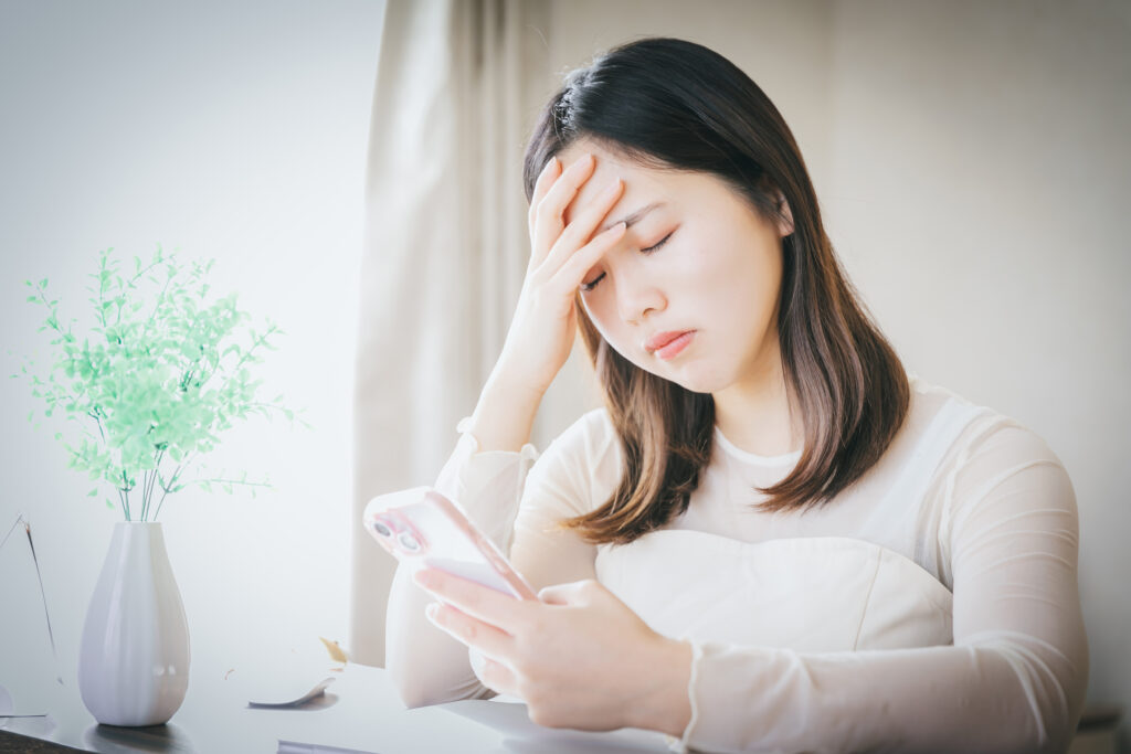 スマホ持って悩む女性　