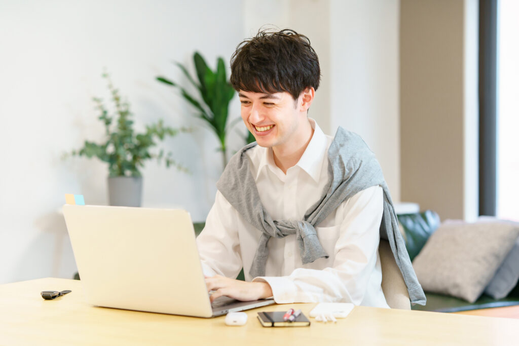 カジュアルな服装でノートPCを使う男性