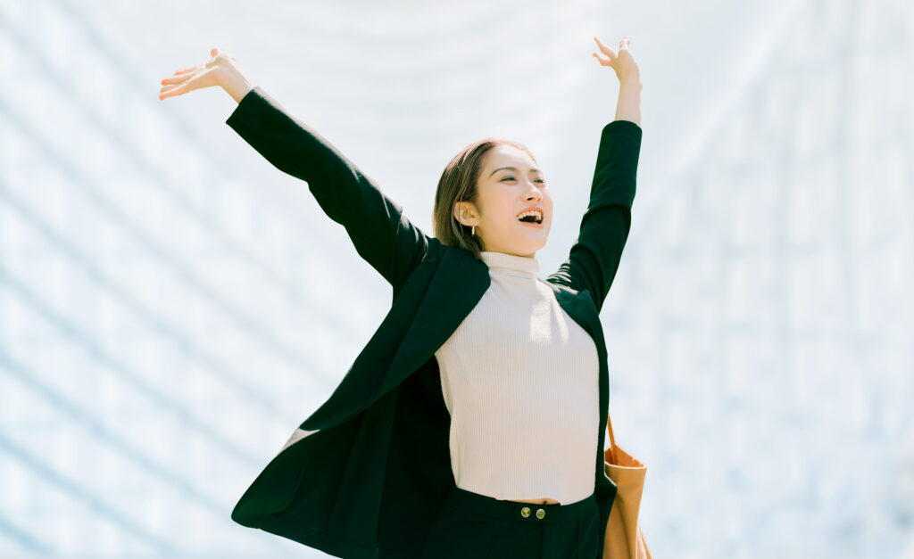両手を広げて喜ぶ笑顔のビジネスウーマン