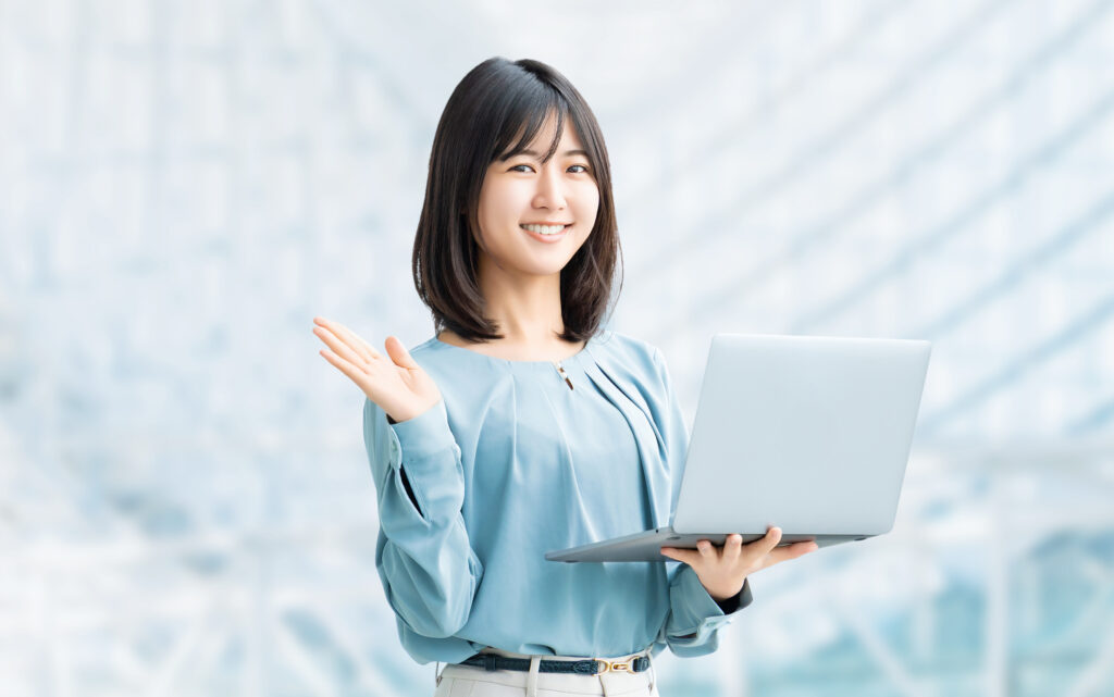 パソコンを持って案内をする笑顔の女性