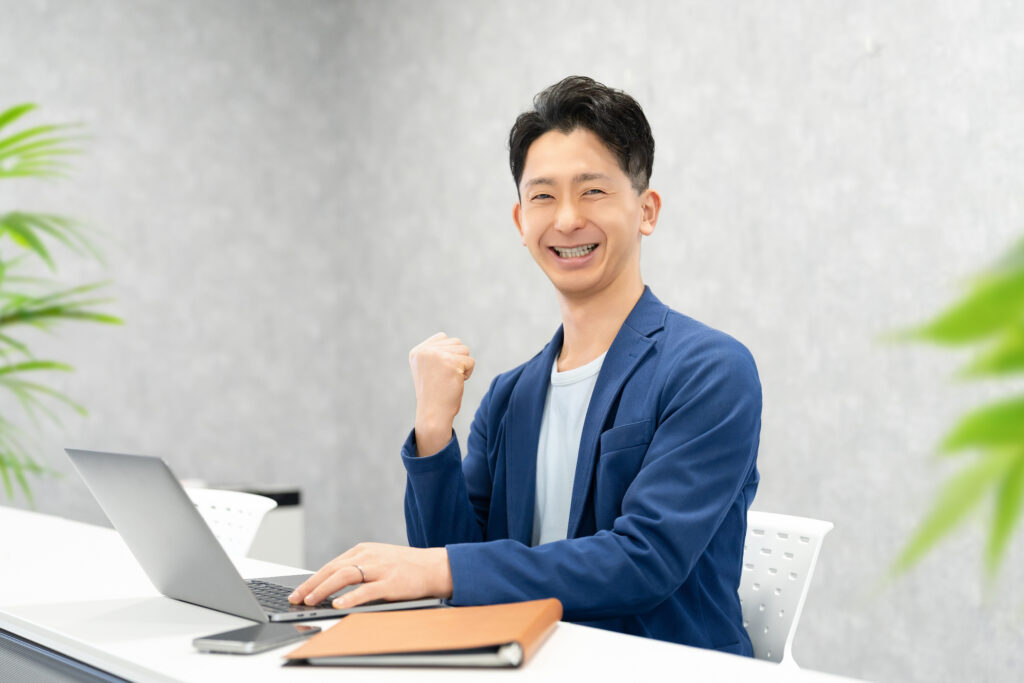 ガッツポーズをする笑顔の男性ビジネスマン