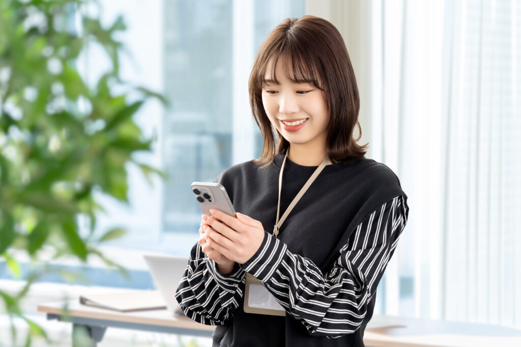 スマホを使う笑顔の女性・ビジネスウーマン