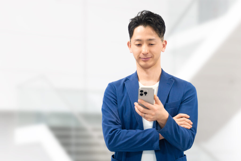 スマホを使う笑顔の男性ビジネスマン