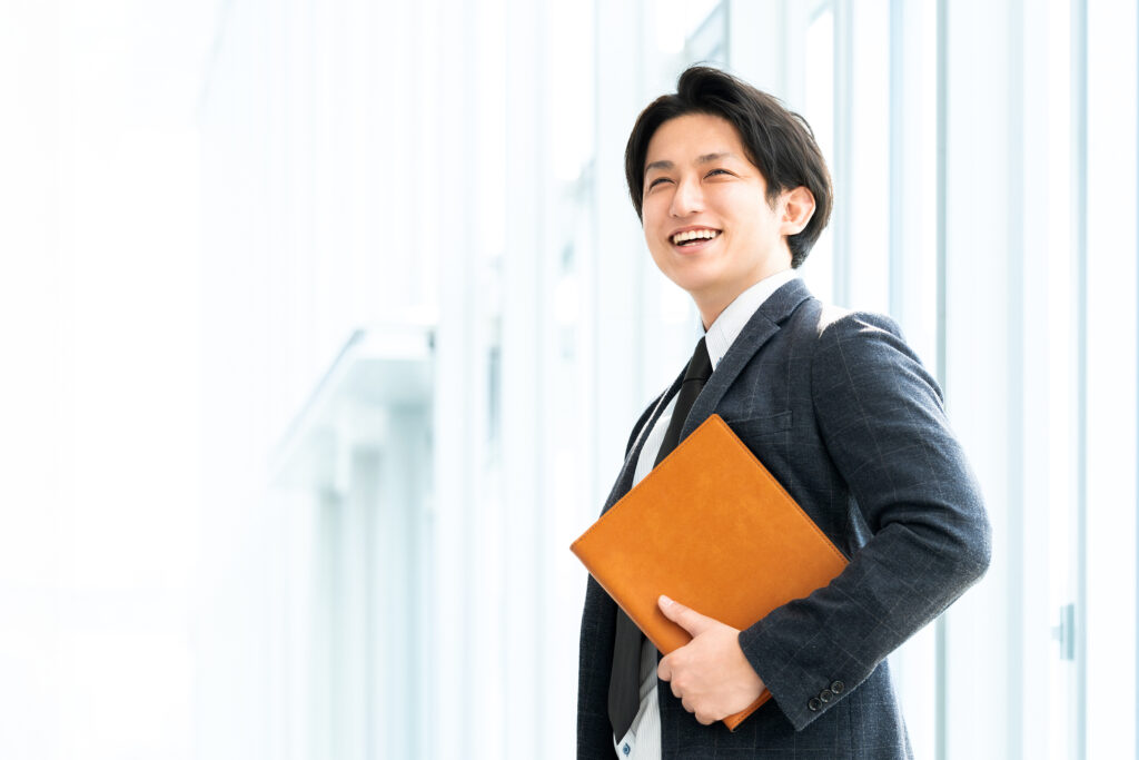 バインダーを持つ笑顔の男性ビジネスマン