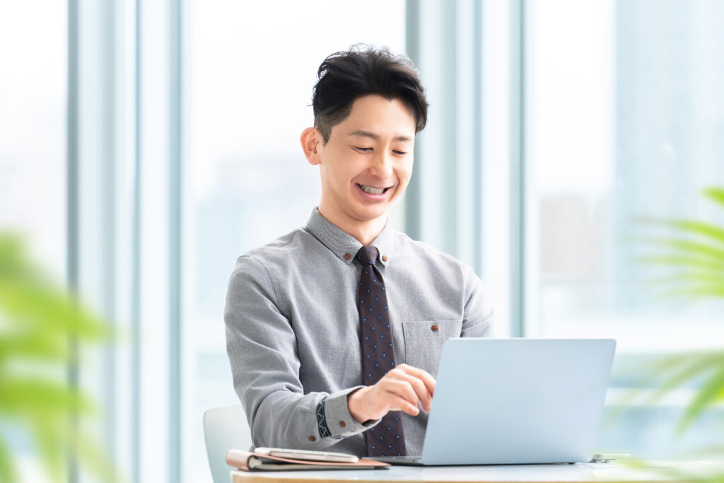 パソコンを使う笑顔の男性