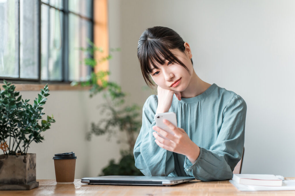 カフェでスマホを使う若いビジネスウーマン