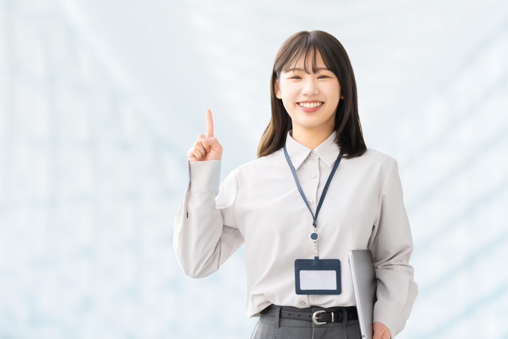 人差し指を立てて案内する笑顔の女性