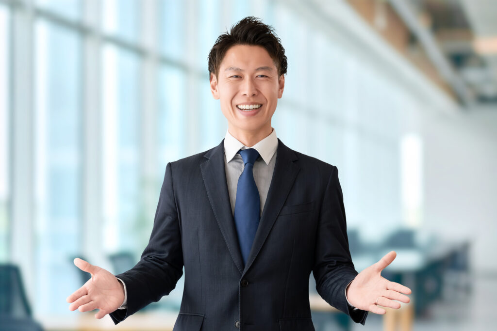 笑顔で案内する男性ビジネスマン