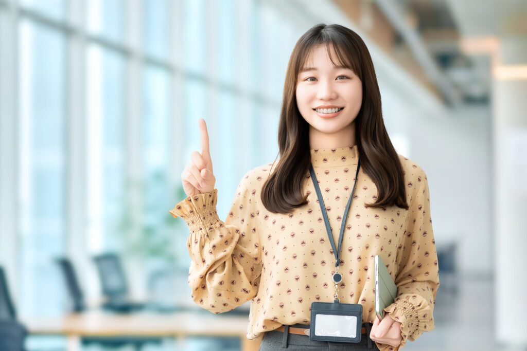 人差し指を立てて案内する笑顔の女性