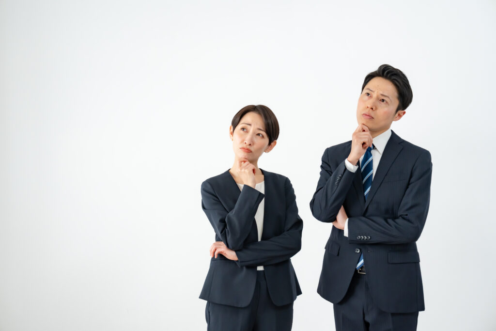 悩むスーツを着た男女