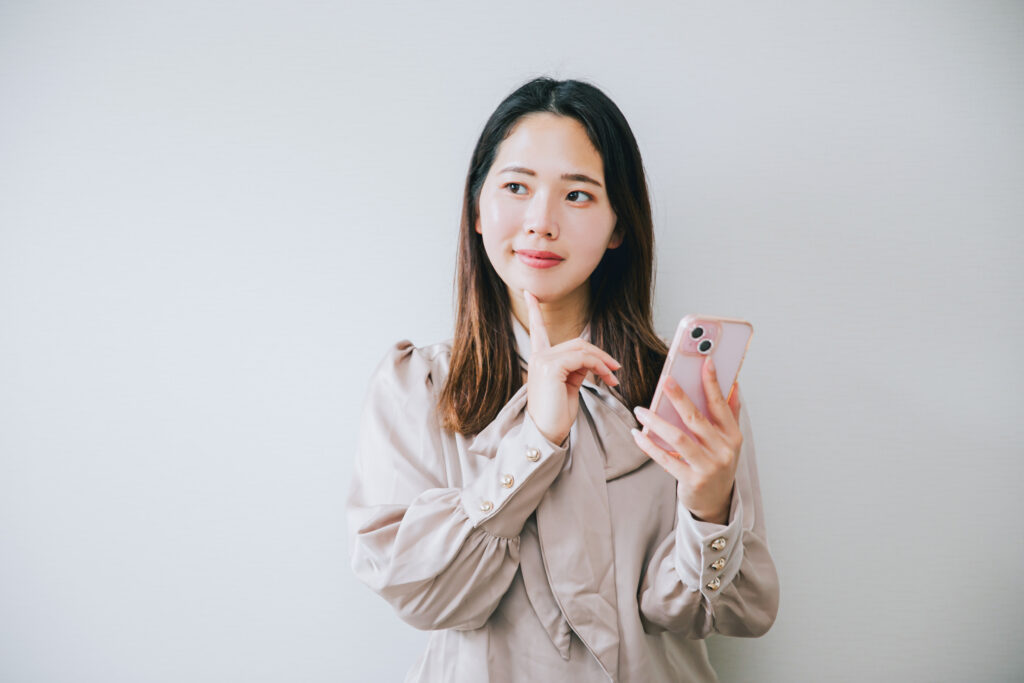 スマホを持って考える20代女性