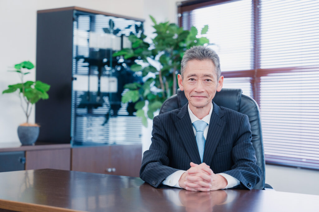 笑顔で椅子に座る経営者の男性
