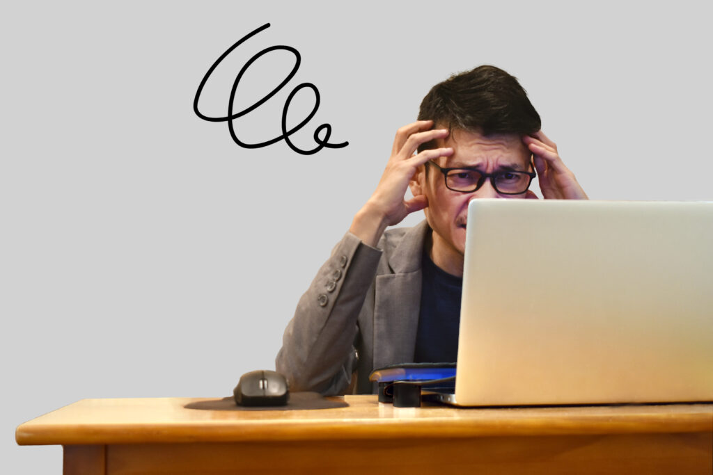 PCの前で頭を抱える男性
