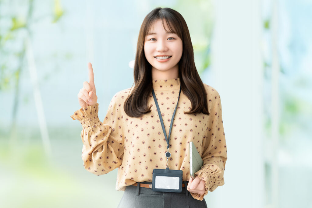 人差し指を立てて案内する笑顔の女性