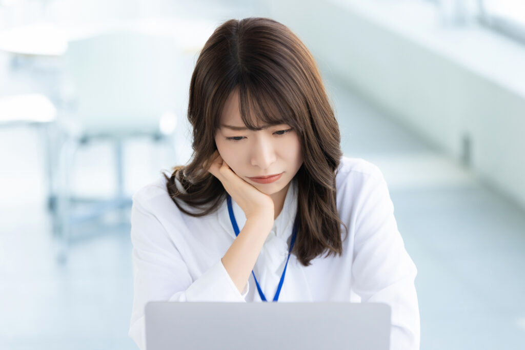 パソコンの画面を見ながら考える女性