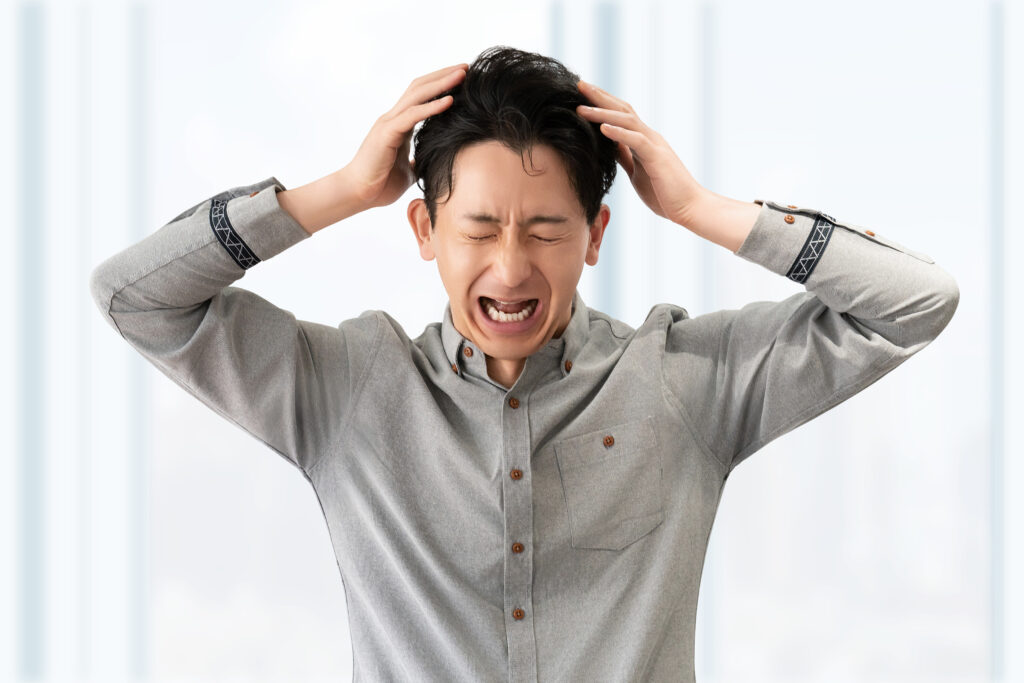頭を抱えて悩む男性ビジネスマン
