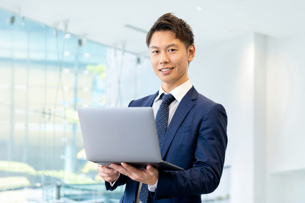 ノートパソコンを持つ笑顔のビジネスマン