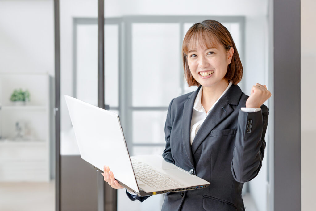 PCと綺麗なオフィスとスーツ女性