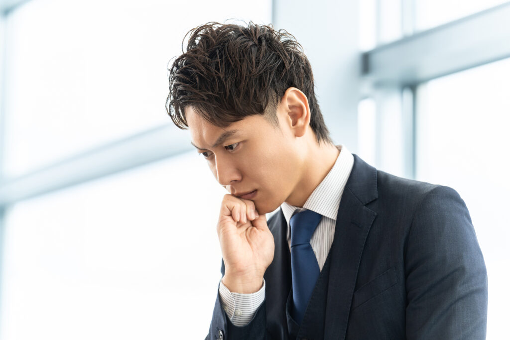 考えごとをする男性ビジネスマン