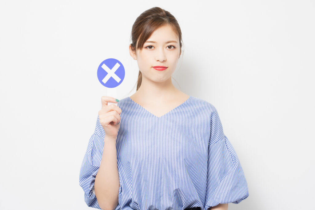 NGのプラカードを持つ若い女性