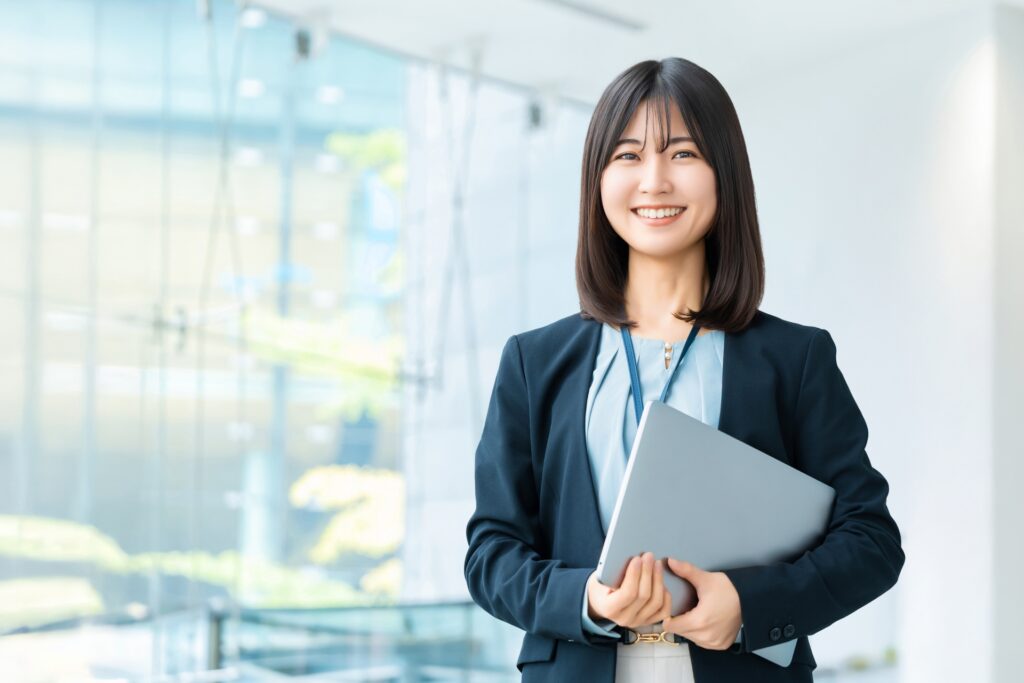 ノートパソコンを持つ笑顔の女性
