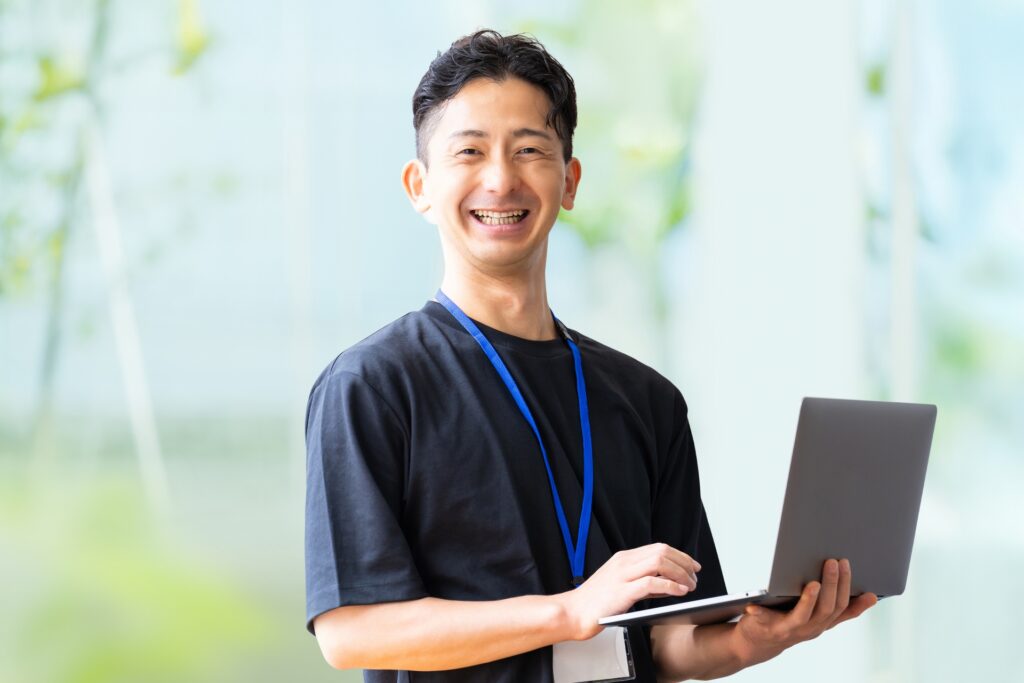 ノートパソコンを持つ笑顔のビジネスマン