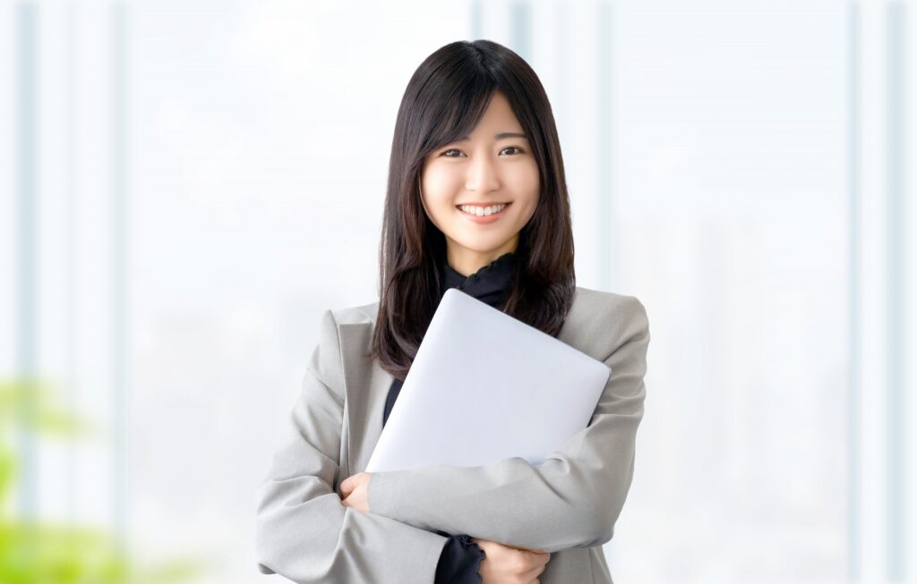 ノートパソコンを持つ笑顔の女性