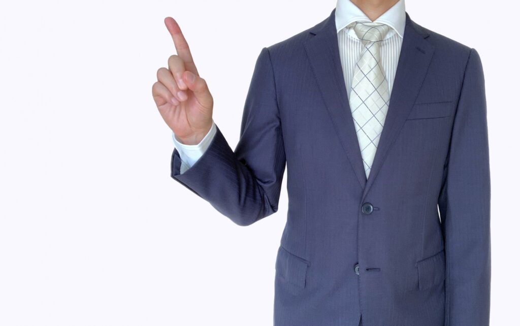 人差し指を立てるビジネスマン
