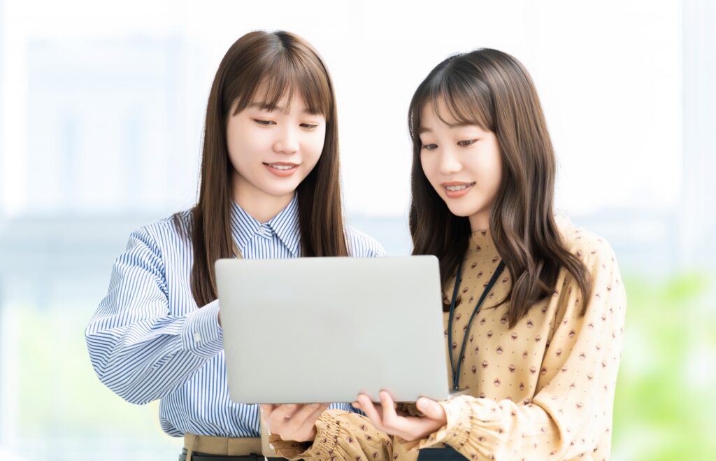 パソコンを見ながら話す2人の女性