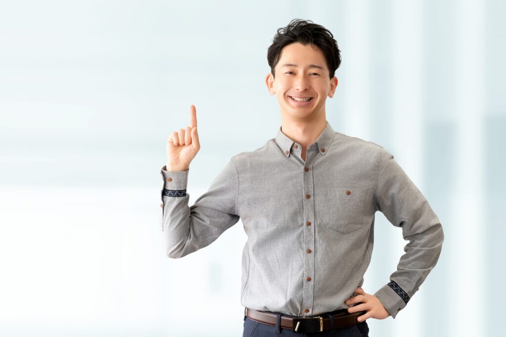 人差し指を立てて案内する男性ビジネスマン