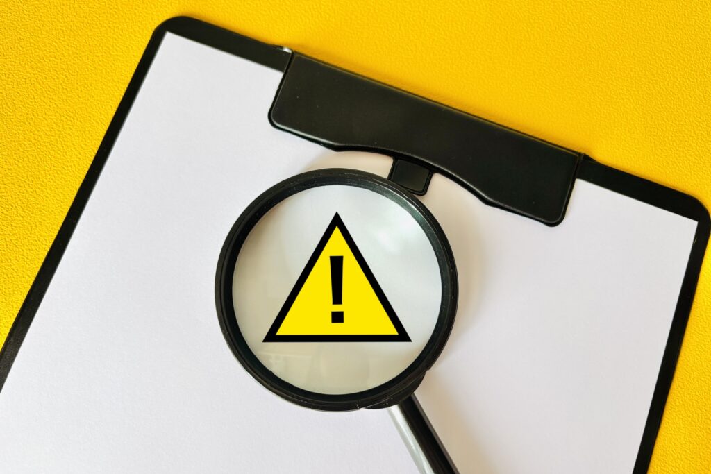 虫眼鏡と注意マークと黄色バック