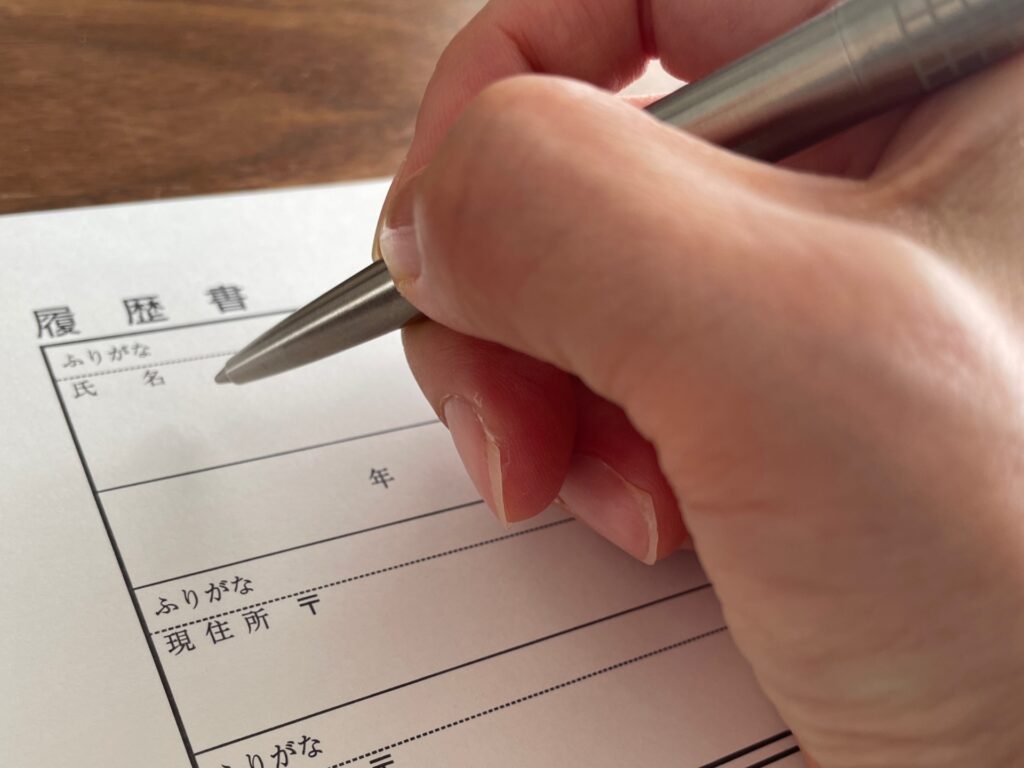 履歴書を記入する女性の手
