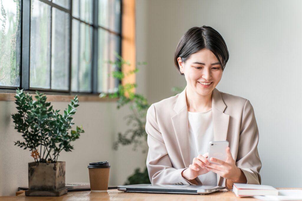 カフェでスマホを使う若いビジネスウーマン