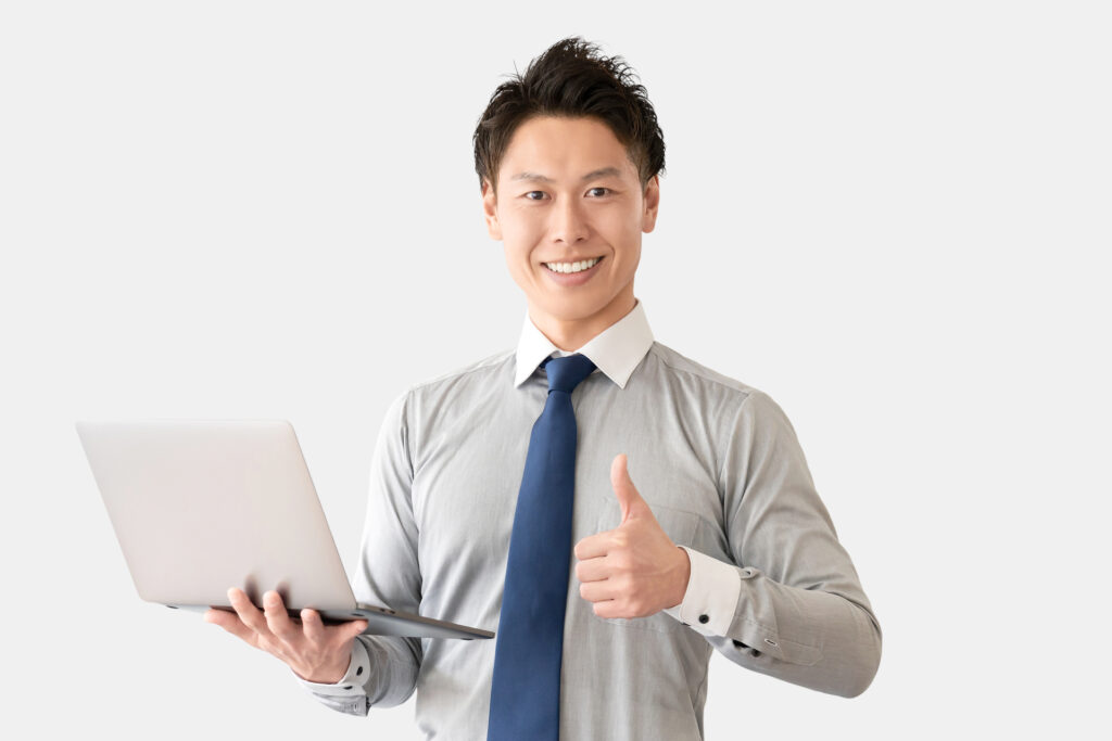 パソコンを持っていいねのポーズをする男性