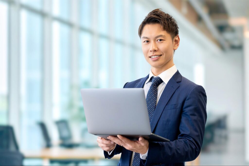 ノートパソコンを持つ笑顔のビジネスマン
