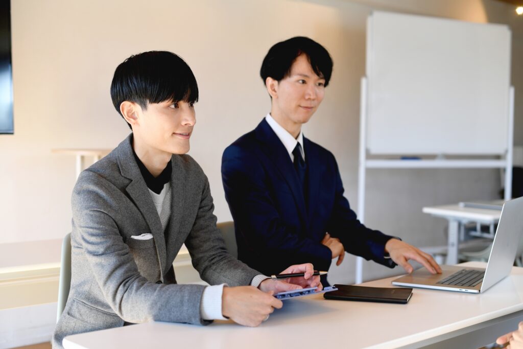 並んで座るビジネスマンのアジア人男性達