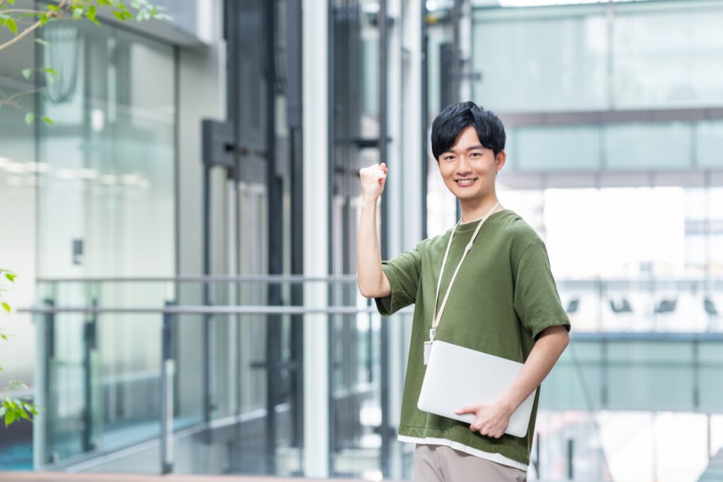 オフィスでガッツポーズする若いエンジニア