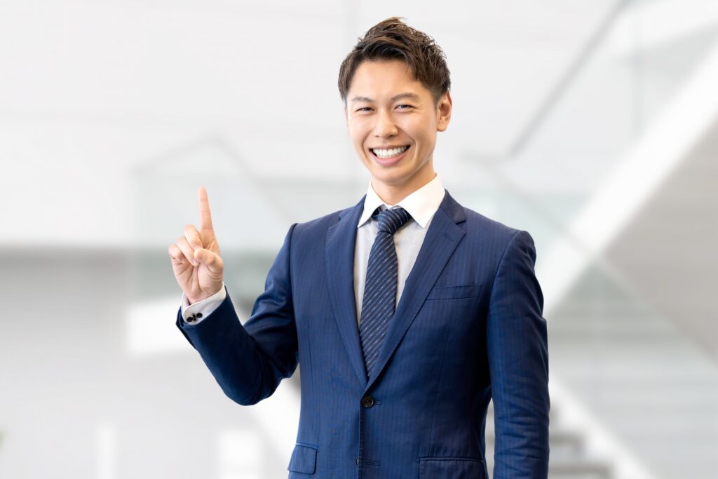 人差し指を立てて案内する男性