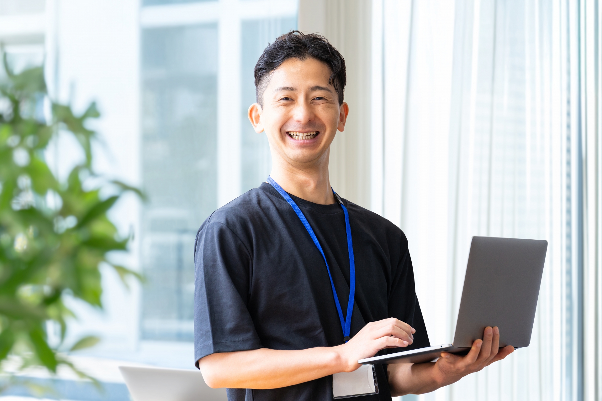 ノートパソコンを持つ笑顔のビジネスマン