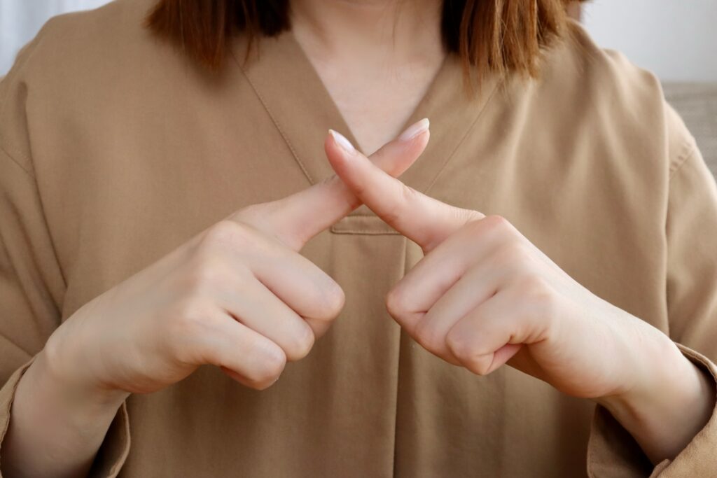 バツポーズの女性の手