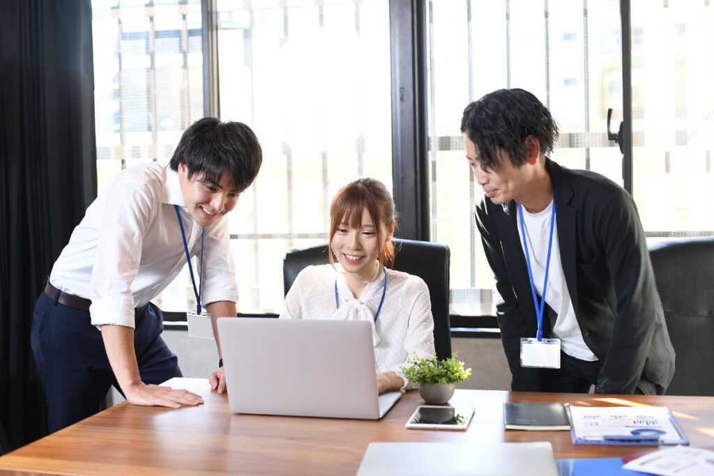 オフィスでパソコンを見ながら仕事をする男性と女性