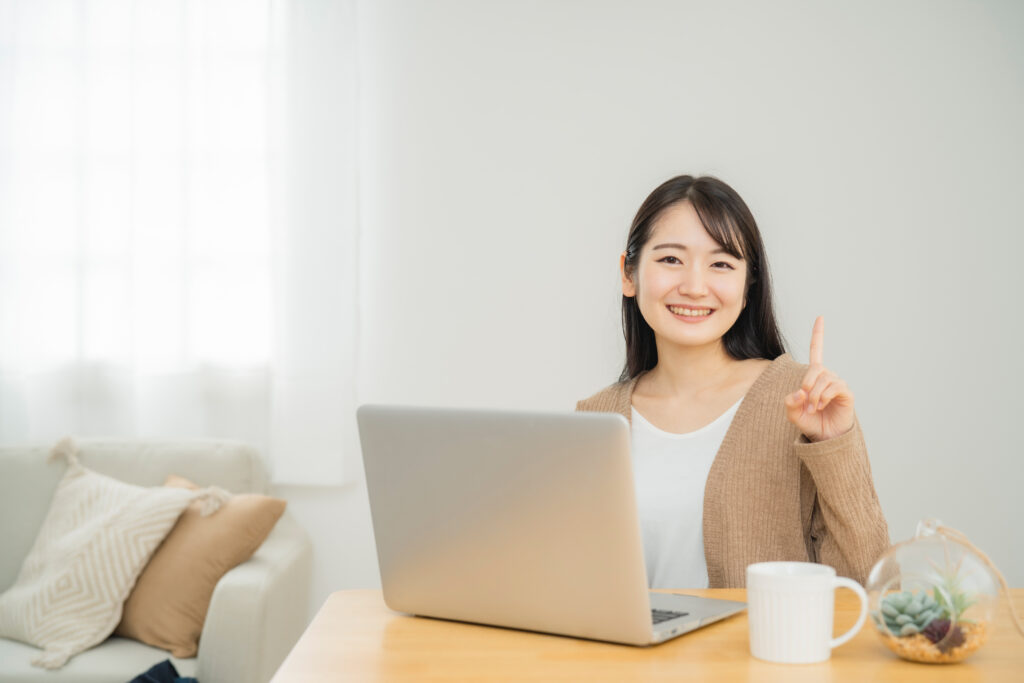 家でノートパソコンを使う女性