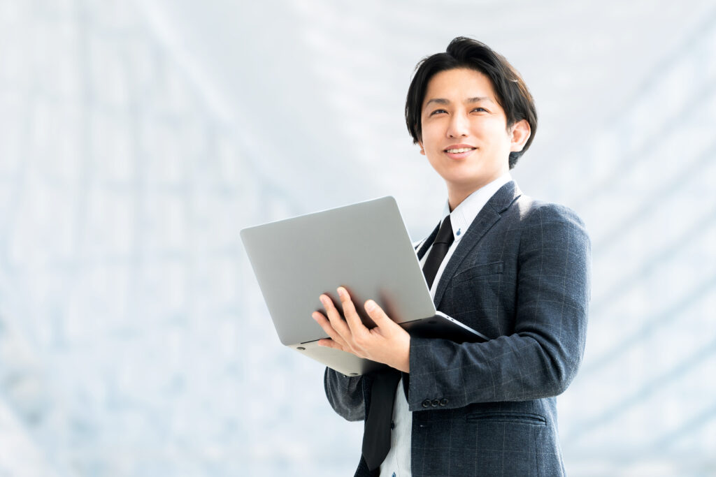 ノートパソコンを持つ笑顔のビジネスマン