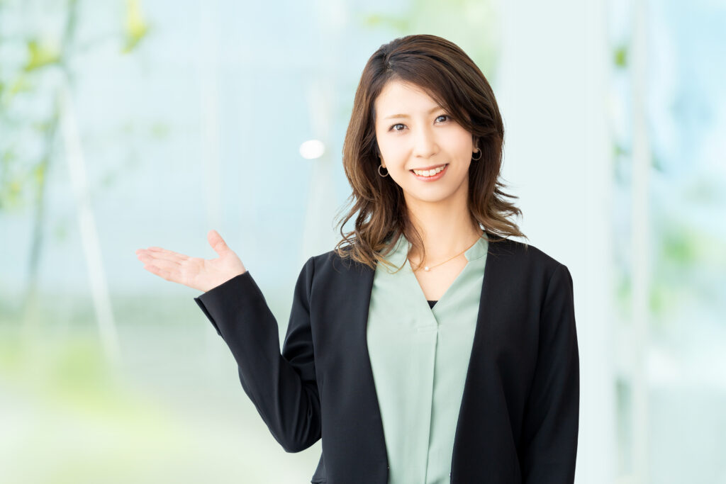 手で案内をする女性