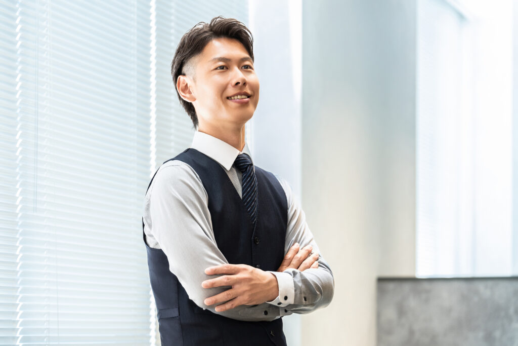 腕組みをする笑顔の男性ビジネスマン